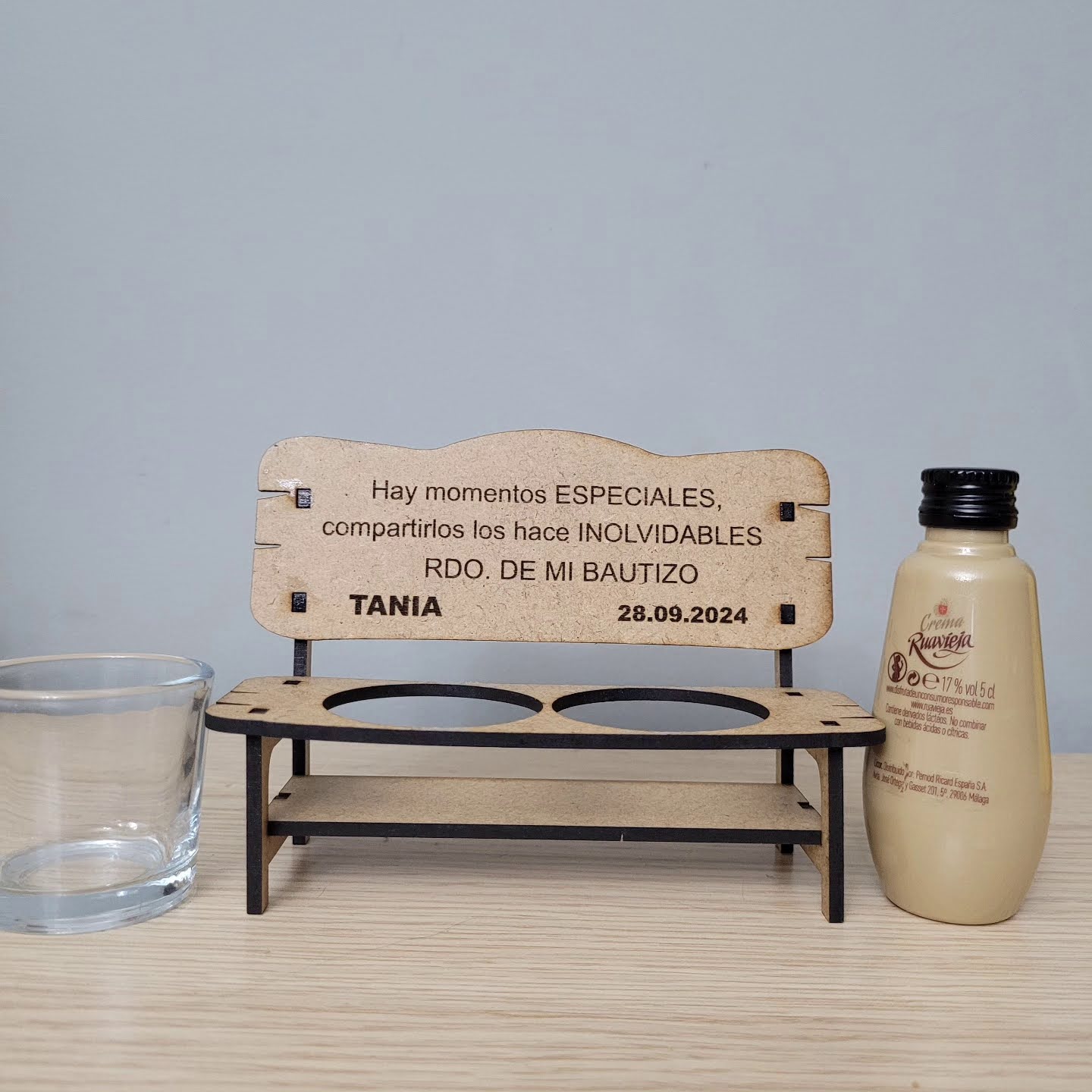 Bancos con vaso de chupito y botellita de crema de orujo de Ruavieja